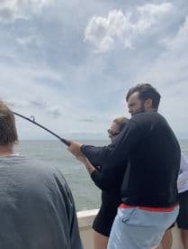 Two anglers actively reeling in a catch while enjoying a day of fishing on the open water.