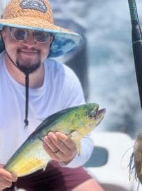 An angler proudly displaying a vibrant Mahi Mahi while fishing on a boat, showcasing the excitement of a successful catch.