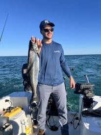 An angler proudly displaying a large fish while aboard a fishing boat, enjoying a day on the water.
