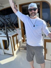 An angler proudly displaying a freshly caught fish aboard a fishing charter, showcasing the excitement of a successful day on the water.