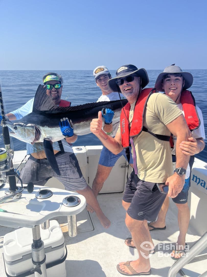 Group of anglers celebrating a successful catch of a large Sailfish while out on a deep-sea fishing trip.