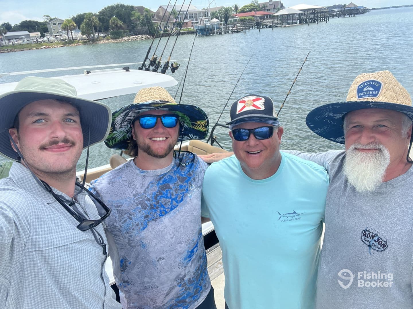 Group of four anglers posing on a boat with fishing rods in the background, enjoying a day on the water.
