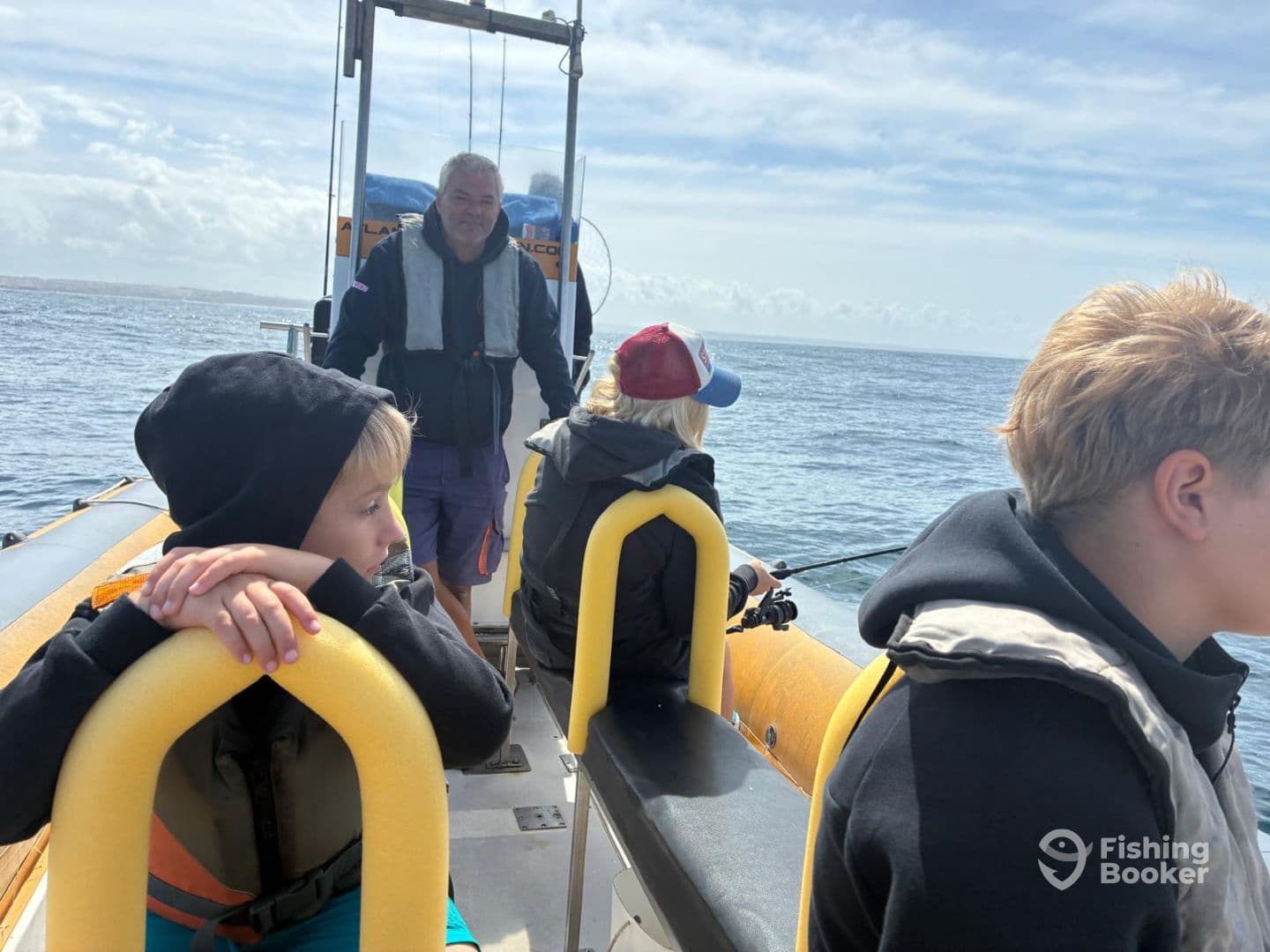 A group of young anglers on a fishing boat, engaged in fishing activities while enjoying a day on the water.