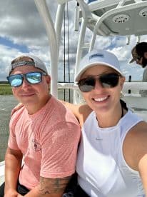 Two anglers enjoying a sunny day on a fishing boat, showcasing the comfortable seating and relaxed atmosphere.