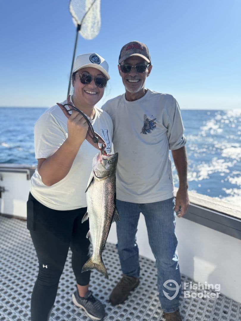 A proud angler displaying a large fish aboard a boat, enjoying a successful day of fishing on the open water.