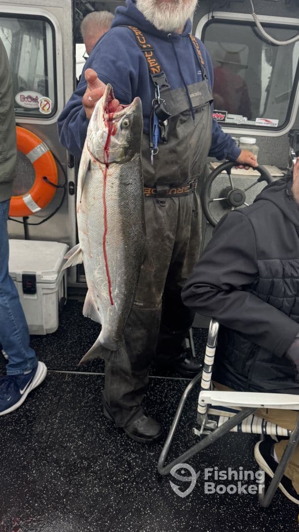An angler proudly displaying a freshly caught fish aboard a fishing charter, showcasing the excitement of the catch.