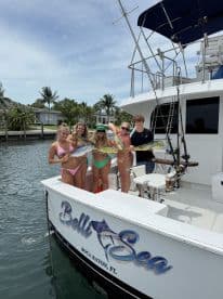 A group of young adults proudly displaying their catch of Mahi Mahi on the Belli Sea charter boat in Boca Raton, FL.