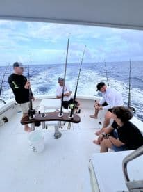 Group of anglers preparing for fishing on a charter boat, showcasing a lively fishing atmosphere in open waters.