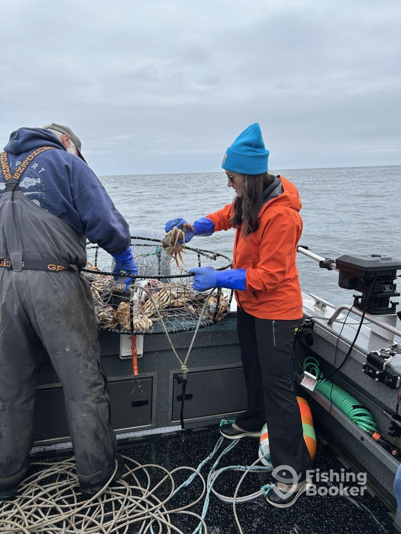Two anglers actively pulling up a crab trap on a fishing boat, showcasing teamwork in a coastal fishing environment.