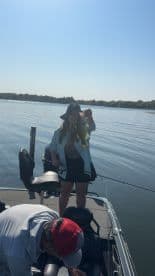 Angler proudly displaying a large bass while fishing on a sunny day, showcasing the excitement of a successful catch.