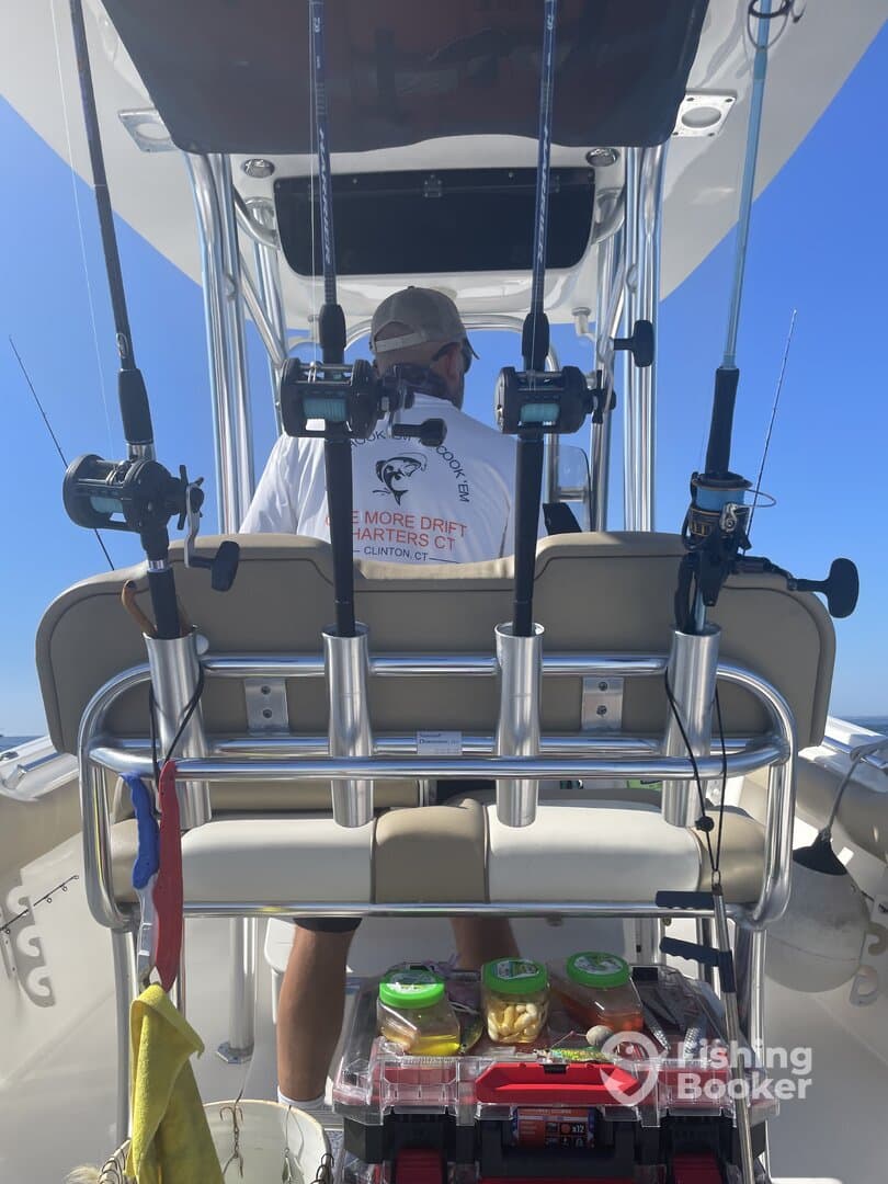 View from the helm of a fishing boat, showcasing the seating and fishing gear setup, perfect for a day on the water.