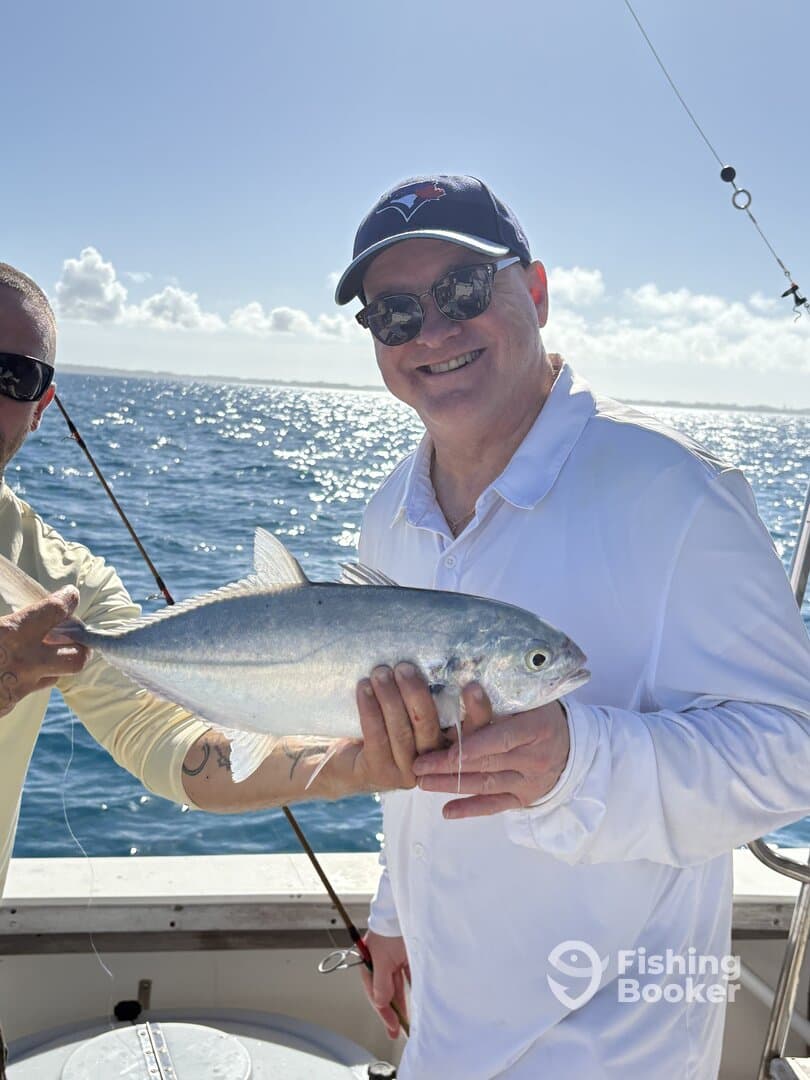 Two anglers proudly displaying a Silverfish while enjoying a sunny day on the water.