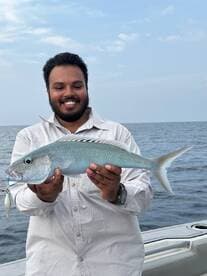 Angler proudly displaying a beautiful Bluefish caught during a fishing trip on the open water.