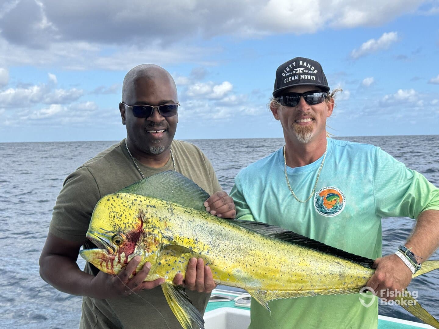 Two anglers proudly displaying a large Mahi Mahi while fishing offshore, showcasing a successful day on the water.