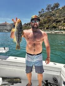Angler proudly displaying a large California Sheephead caught during a sunny day on the water.