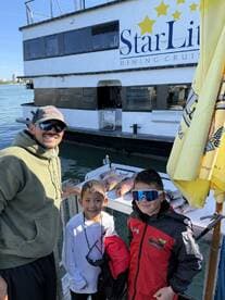 A proud moment for a family as they showcase their catch of fish on a dock after a successful fishing trip.