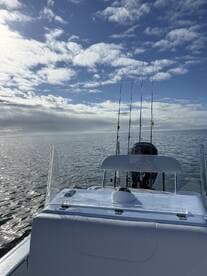 A view from the helm of a fishing boat, showcasing the calm waters and clear skies, ideal for a day of fishing.