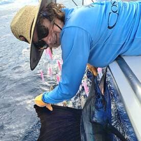 Angler actively reeling in a large fish while fishing offshore, showcasing the excitement of deep-sea fishing.