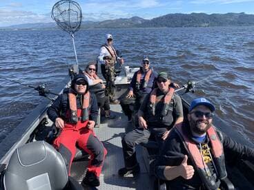 A group of anglers enjoying a day on the water, seated inside a fishing boat, ready for an exciting fishing adventure.