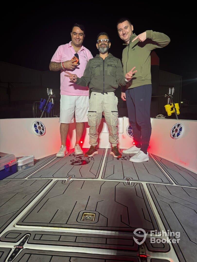 Three friends enjoying a night out on a fishing boat, showcasing the interior with modern features and ambient lighting.