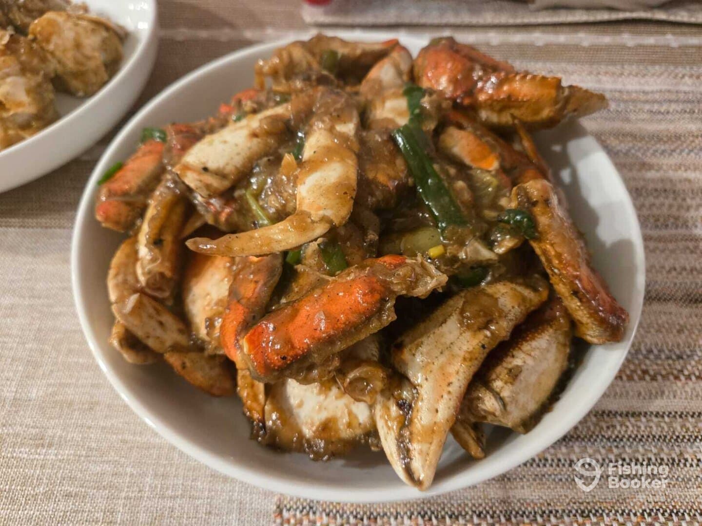 A close-up of a bowl filled with cooked crab, showcasing a flavorful dish, but lacking any fishing context.