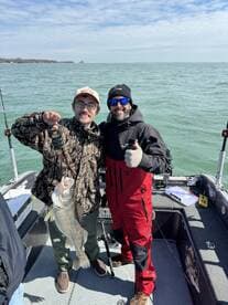 Two anglers proudly displaying a large Walleye caught during a fishing trip on the lake.