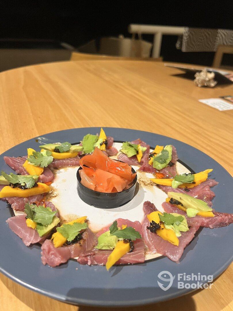 A beautifully arranged plate of sashimi featuring various garnishes, showcasing a culinary presentation rather than a fishing catch.