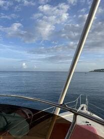 View from the helm of a boat, showcasing the calm waters and clear skies, perfect for a day of fishing.