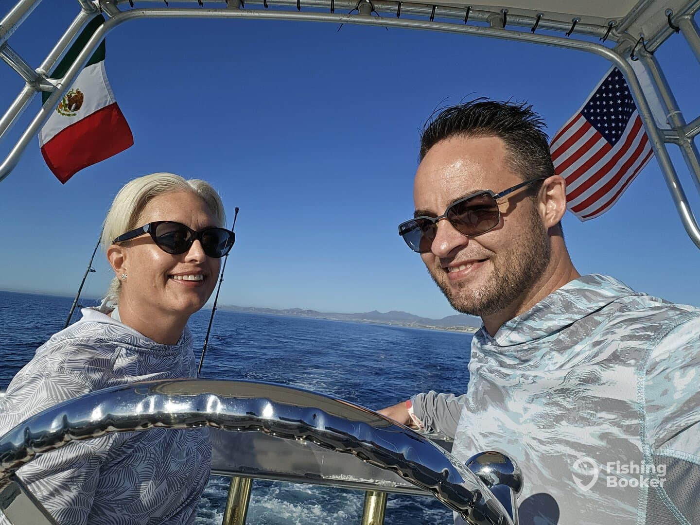 A couple enjoying a sunny day on a fishing boat, with the Mexican and American flags visible in the background.