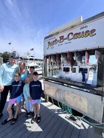 A family poses proudly in front of their catch, featuring several Snapper displayed on a board at the dock in Destin, Florida.