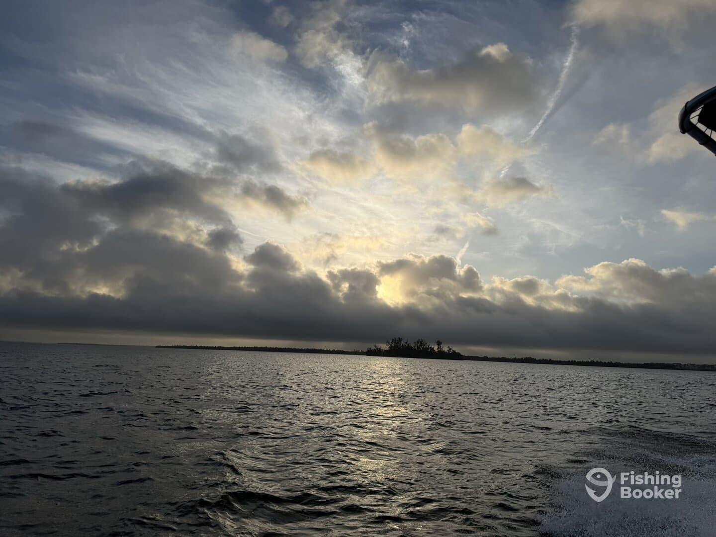 A scenic view of the water and clouds during a fishing trip, showcasing the tranquil atmosphere of the fishing environment.
