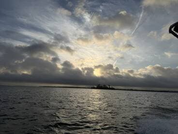 A scenic view of the water and clouds during a fishing trip, showcasing the tranquil atmosphere of the fishing environment.