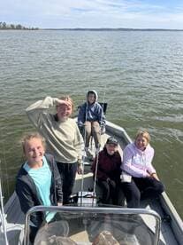 A group of young anglers enjoying a day on a fishing boat, showcasing camaraderie and excitement on the water.
