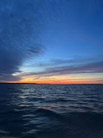 A serene sunset over the water, capturing the tranquil beauty of the fishing environment.