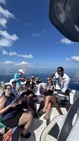 A cheerful group of anglers displaying their catch of multiple fish while enjoying a sunny day on the water.