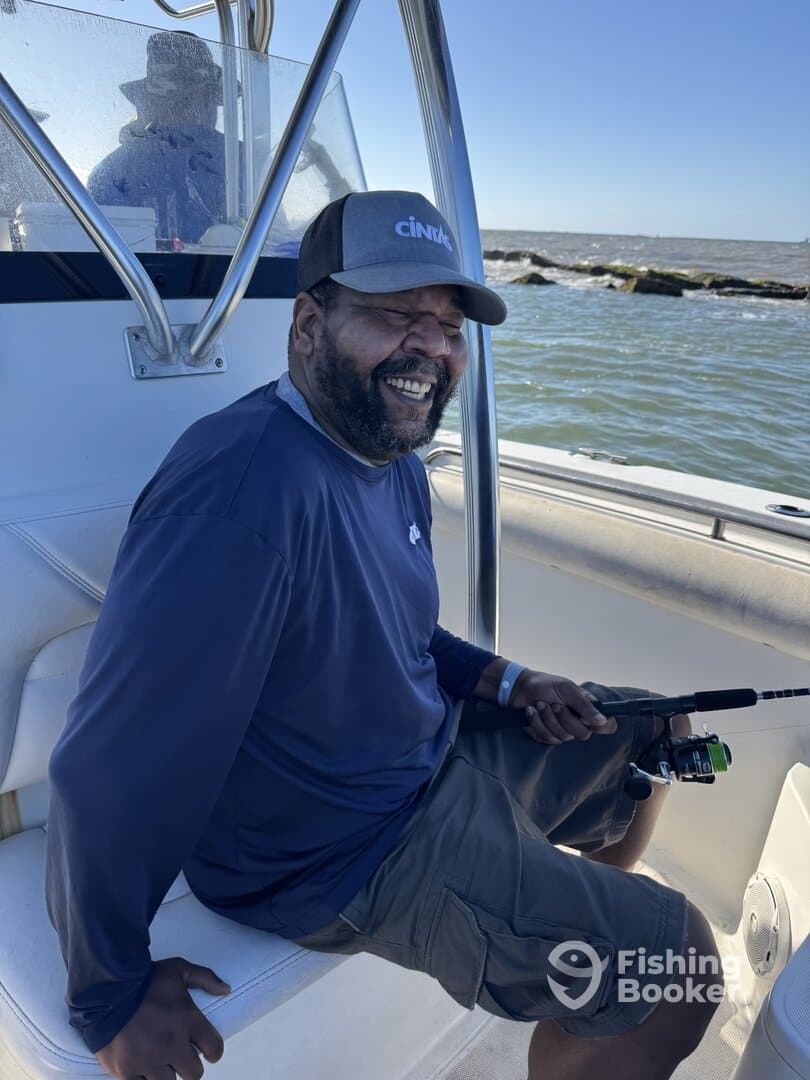 A smiling angler seated inside the boat, enjoying a day of fishing on the water.