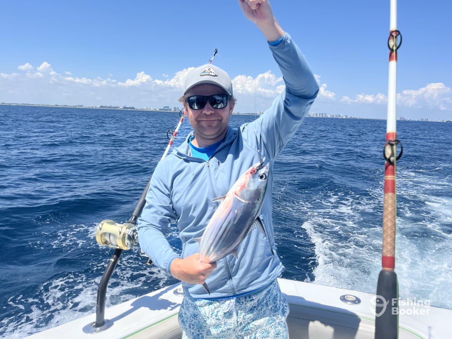 Angler proudly displaying a freshly caught fish while out on the open water, showcasing a sunny day of fishing.