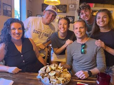 A family enjoying a meal together, showcasing a platter of fried seafood in a casual dining setting.