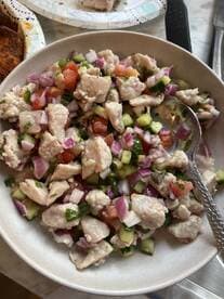 A bowl of ceviche featuring diced fish mixed with fresh vegetables, showcasing a vibrant and colorful dish.