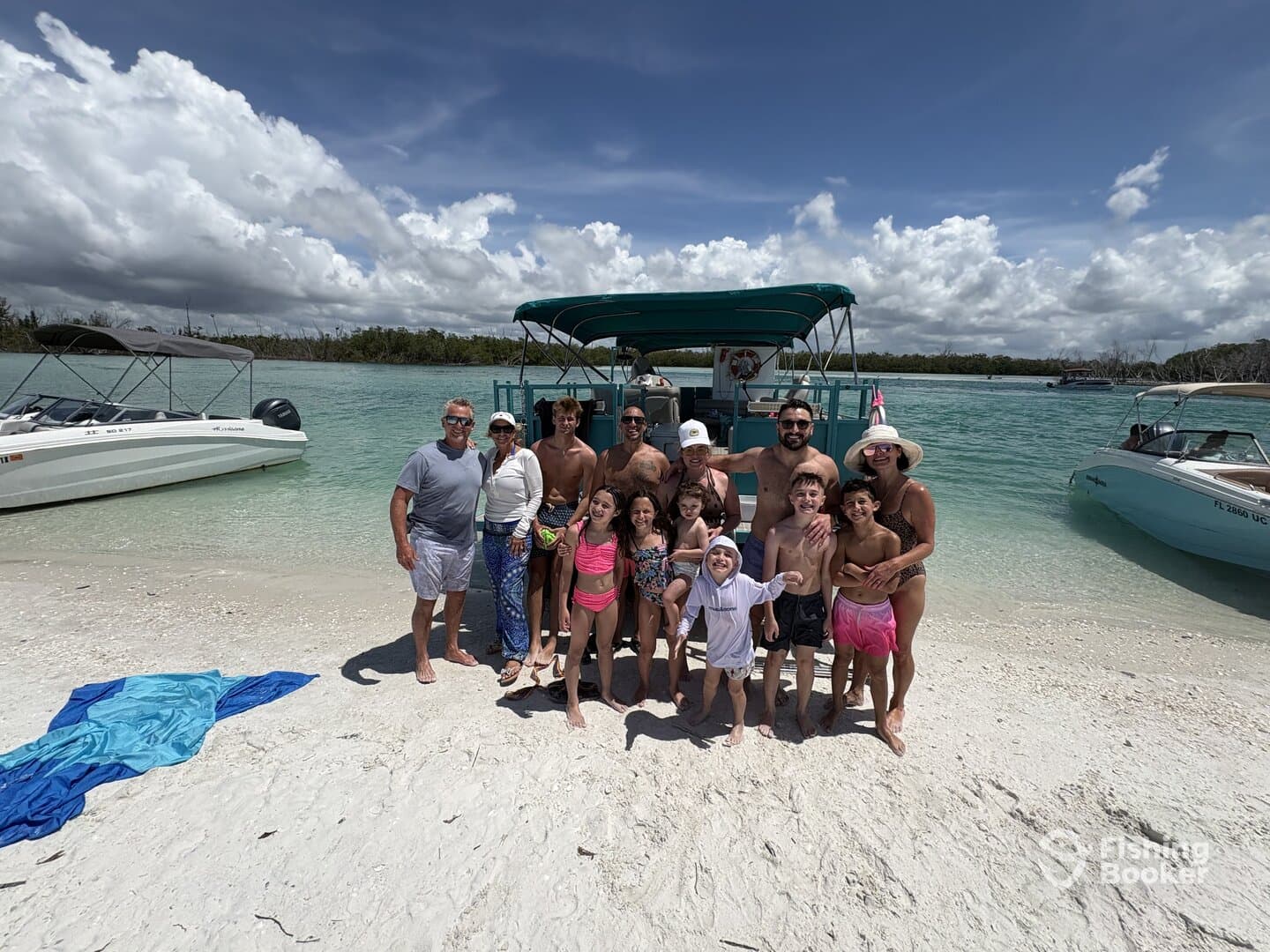 A large family group enjoying a day at the beach near their boat, showcasing a fun and relaxed atmosphere.