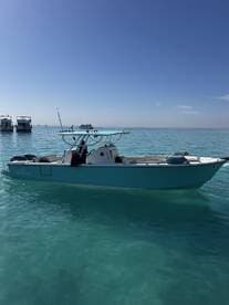 A sleek Bowfin boat anchored in clear turquoise waters, showcasing a beautiful day for fishing.