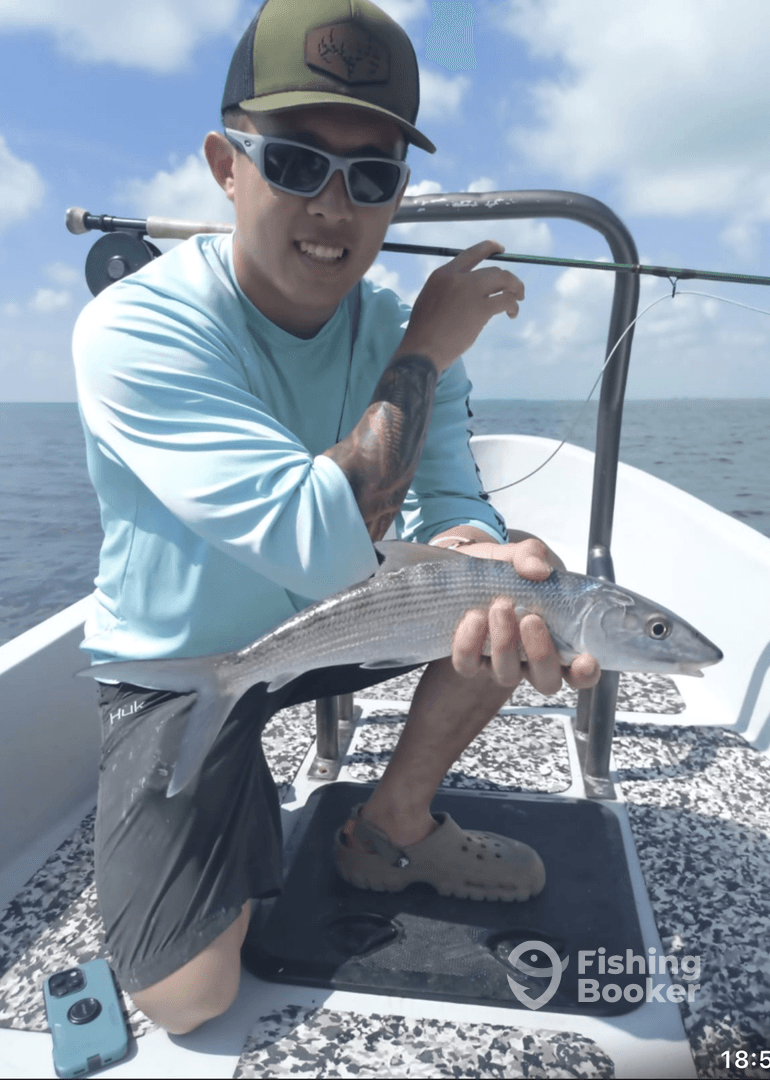 Angler proudly displaying a caught fish while fishing on a boat in open water.