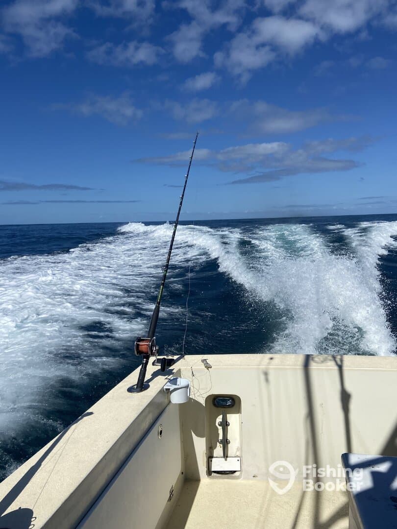 View from the helm of a fishing boat, showcasing the open ocean and a fishing rod ready for action.