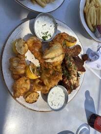 A plate of fried fish and sides, showcasing a variety of seafood dishes, perfect for a post-fishing meal.