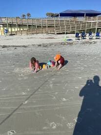 Two children playing in the sand on a beach, showcasing a fun day outdoors.