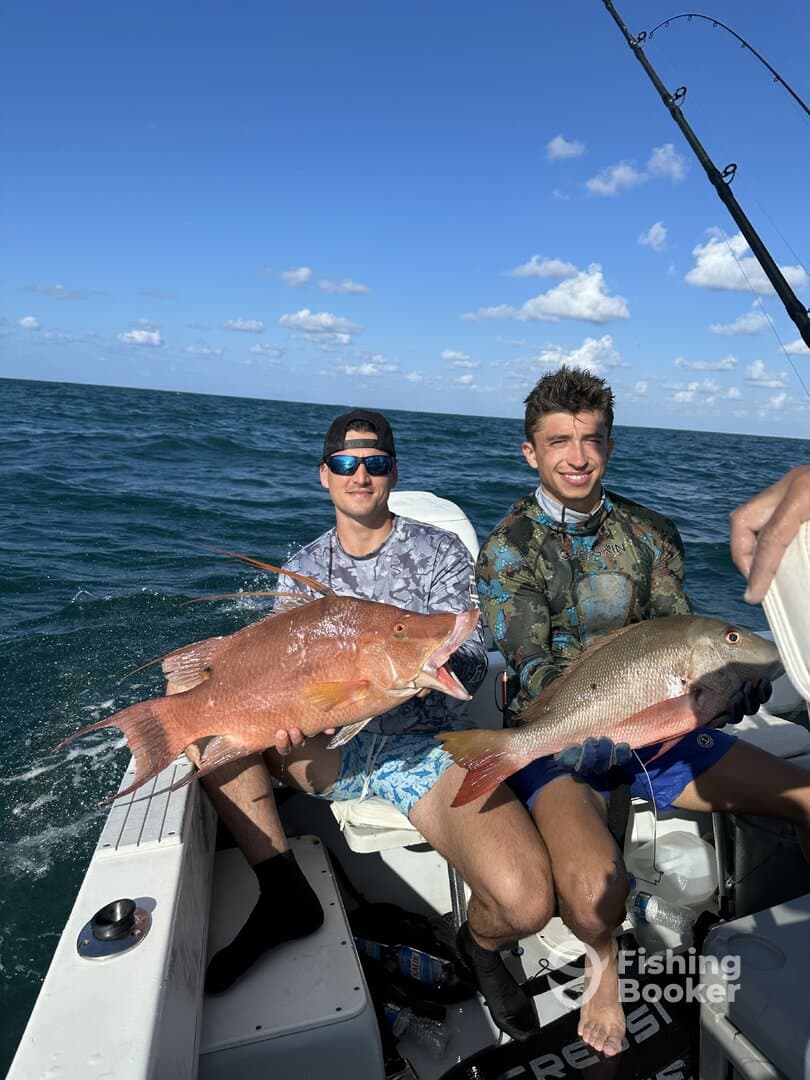 Two anglers proudly displaying their catch of colorful Snapper while fishing in open waters.