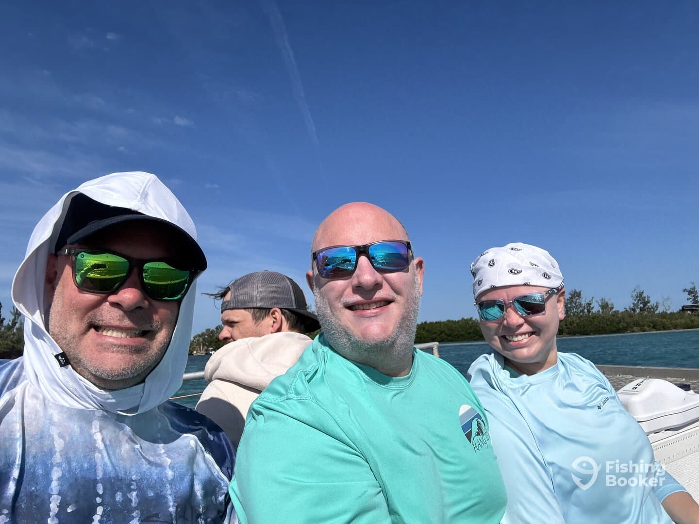 Three anglers enjoying a sunny day on the boat, dressed in fishing attire and sunglasses, ready for an adventure.