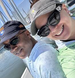 Two anglers enjoying a sunny day on the boat, showcasing a relaxed atmosphere before heading out for fishing.