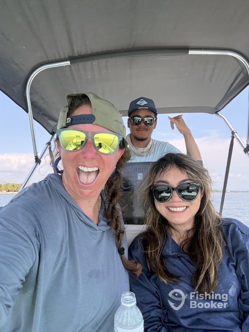 Three friends enjoying a fun moment on a boat, showcasing a relaxed atmosphere while out on the water.