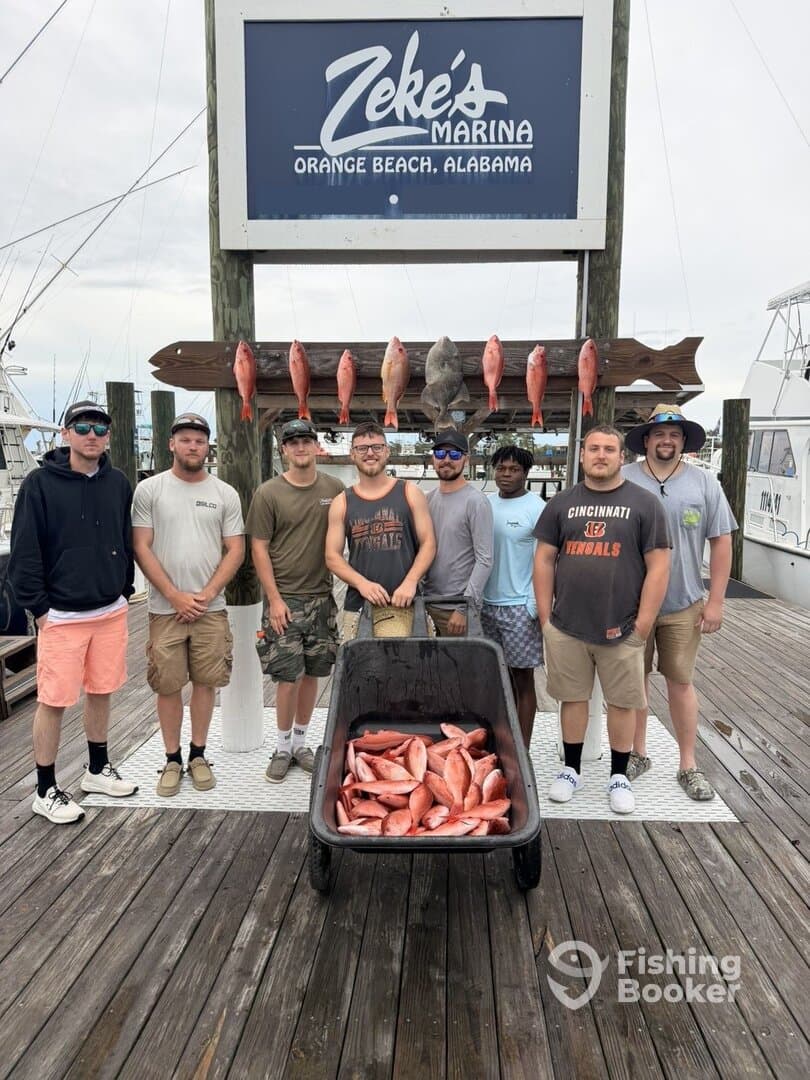 A group of anglers proudly posing with their catch of red snapper displayed on a board at Zeke's Marina in Orange Beach, Alabama.